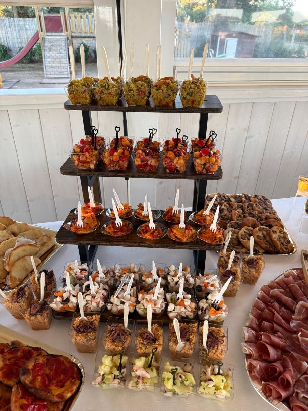 Allestimento a più livelli con antipasti, insalate di mare e finger food