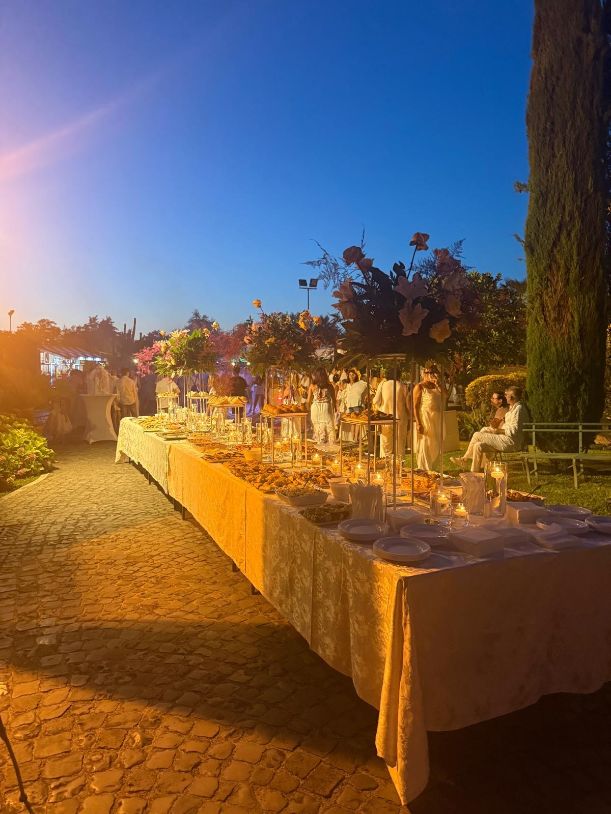 Lungo tavolo allestito per un matrimonio al tramonto